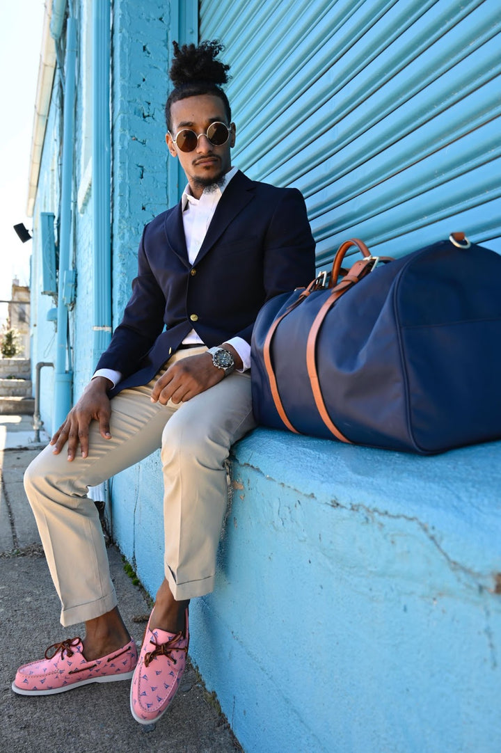 Man sits on ledge wearing pink boat shoes